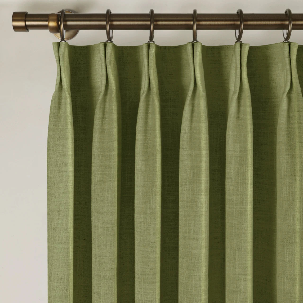 Jade Green Olive Liz linen curtains viewed at an angle in a softly styled room with natural daylight