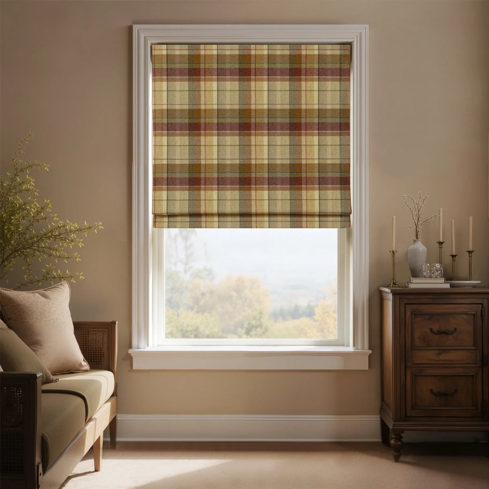 Interior room with a window featuring a beige, brown, and red plaid Roman blind, a dark wood dresser with brass candlesticks and a light gray vase of dry branches, and a beige daybed overlooking a hazy rural landscape