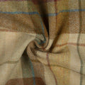 Woven wool fabric, a close-up of a rustic plaid pattern featuring earthy brown and beige tones with subtle blue and red accent lines