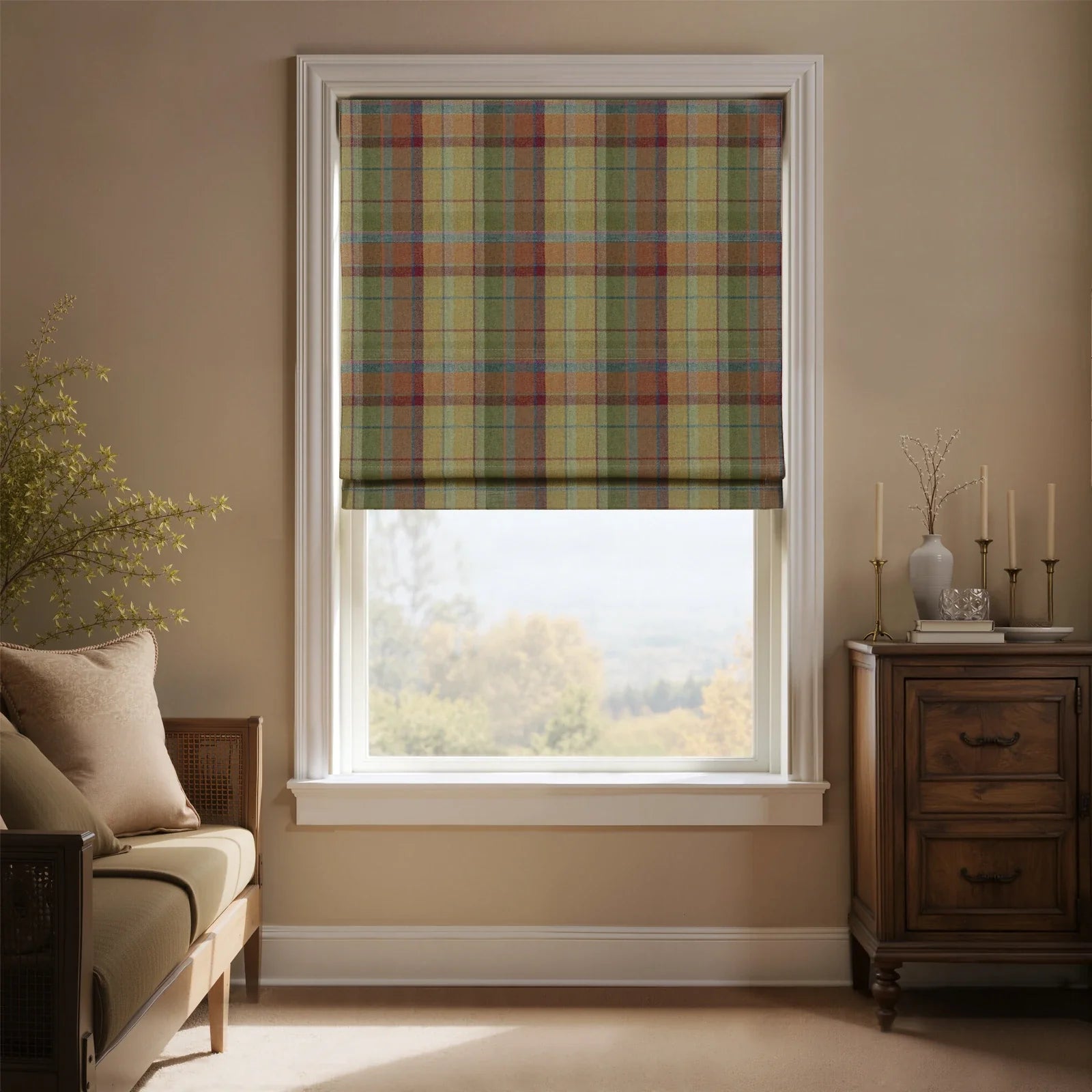 An inviting room with a window featuring a colorful plaid Roman blind in muted red, green, and gold tartan, offering a scenic autumnal landscape view, complemented by a light wood daybed and a dark antique cabinet with candles