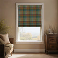 Photography of a cozy living room window with a colorful plaid Roman blind overlooking a hazy autumn landscape, accompanied by elegant dark wood furnishings