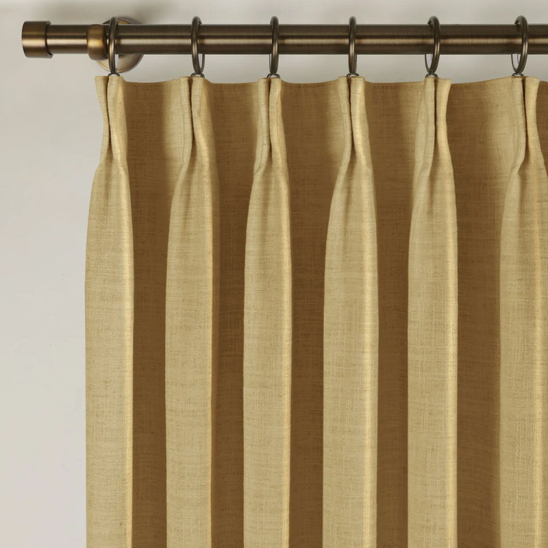 Khaki Liz linen curtains viewed at an angle in a softly styled room with natural daylight