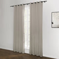 A pair of light taupe grommet top curtains on a black rod framing a bright window with natural light, complementing a dark wood floor and an abstract black and white framed artwork on a white wall