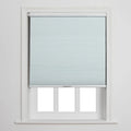 Photograph of a light blue cellular Blind partially covering a white-framed window with three visible lower panes against a plain white wall