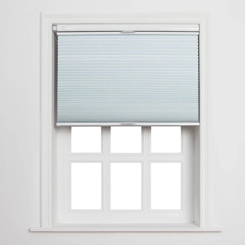 Light blue pleated cellular Blind covering the top portion of a clean white multi-pane window featuring six clear sections and a prominent sill, set against a crisp white interior wall