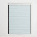 A window displaying a light blue cellular Blind with distinct horizontal pleats, framed by crisp white trim and featuring a discreet bottom rail handle