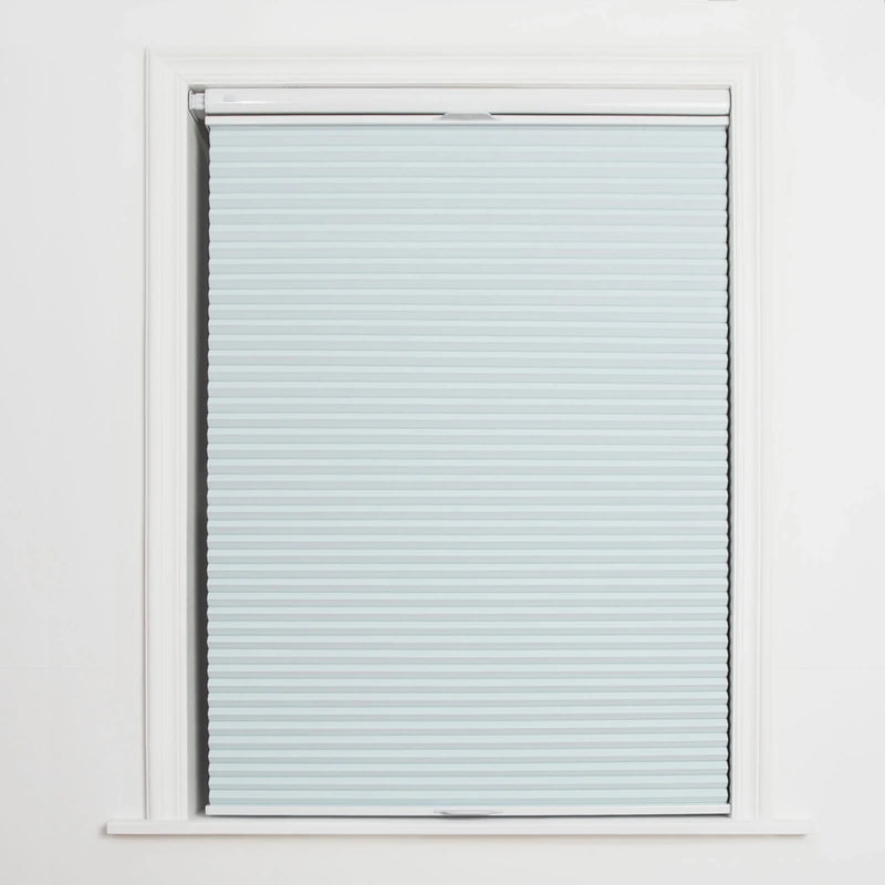 A window displaying a light blue cellular Blind with distinct horizontal pleats, framed by crisp white trim and featuring a discreet bottom rail handle