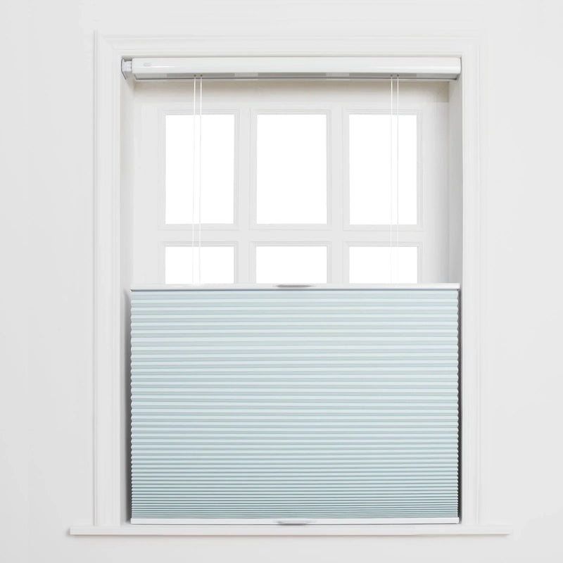 Photograph of a white framed window with a light blue cellular top-down bottom-up Blind featuring subtle horizontal stripes and visible white pull cords, revealing the upper six panes