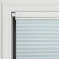 Photograph of a pale blue cellular pleated window Blind installed within a white decorative window frame showing its clean white headrail with a subtle oval adjustment button