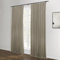 Pair of beige floor-length curtains suspended from a black rod with rings in a contemporary room, framing a white-paned window, complemented by dark hardwood floors and an abstract black and white artwork on the adjacent wall