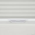 Close-up of textured light grey horizontal window Blinds with a translucent white plastic pull tab handle on a clean white windowsill