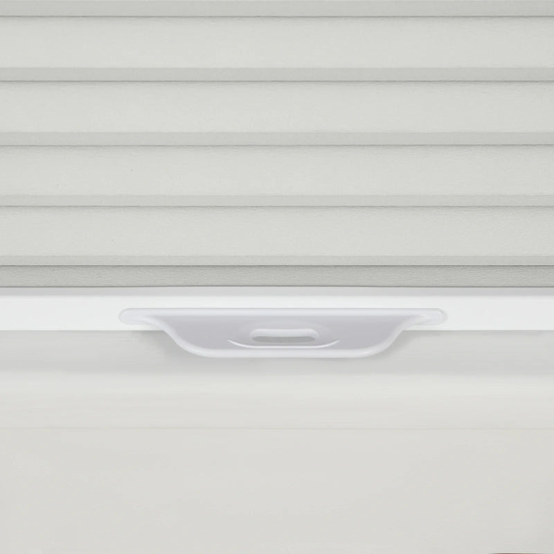 Close-up of textured light grey horizontal window Blinds with a translucent white plastic pull tab handle on a clean white windowsill