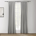 Medium gray rod-pocket curtains on a black rod over a white multi-pane window with an abstract artwork on the adjacent wall and a beige rug on the floor