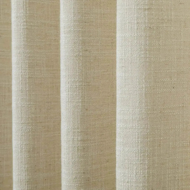 Close-up of light beige textured woven fabric with distinct vertical folds and natural fiber details