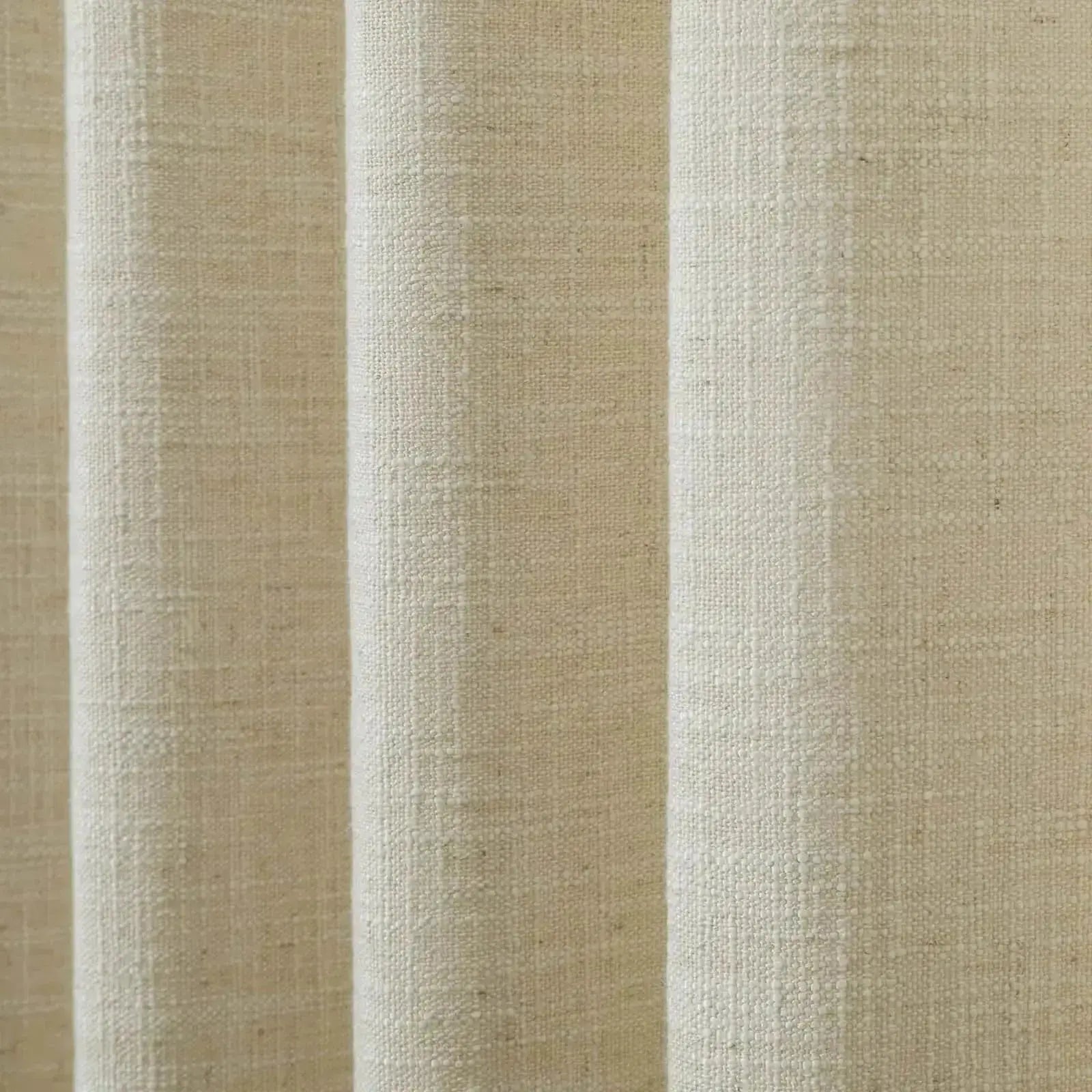 Close-up of light beige textured woven fabric with distinct vertical folds and natural fiber details