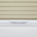 Photograph of textured beige horizontal window Blinds above a smooth white window frame featuring a subtle recessed pull handle