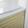 Close-up of sand-colored textured cellular window Blinds featuring a crisp white headrail and two visible thin control strings