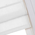 Close-up view of a white linen-textured Roman blind showing soft horizontal folds and a pearl-like beaded chain mechanism for adjustment