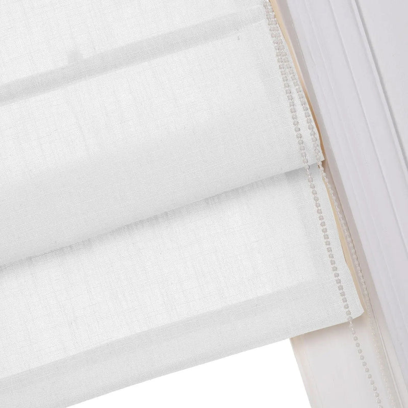 Close-up view of a white linen-textured Roman blind showing soft horizontal folds and a pearl-like beaded chain mechanism for adjustment