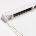 Close-up of a white roller blind mechanism showing the aluminum headrail, the plastic beaded chain control, and the textured white fabric of the blind