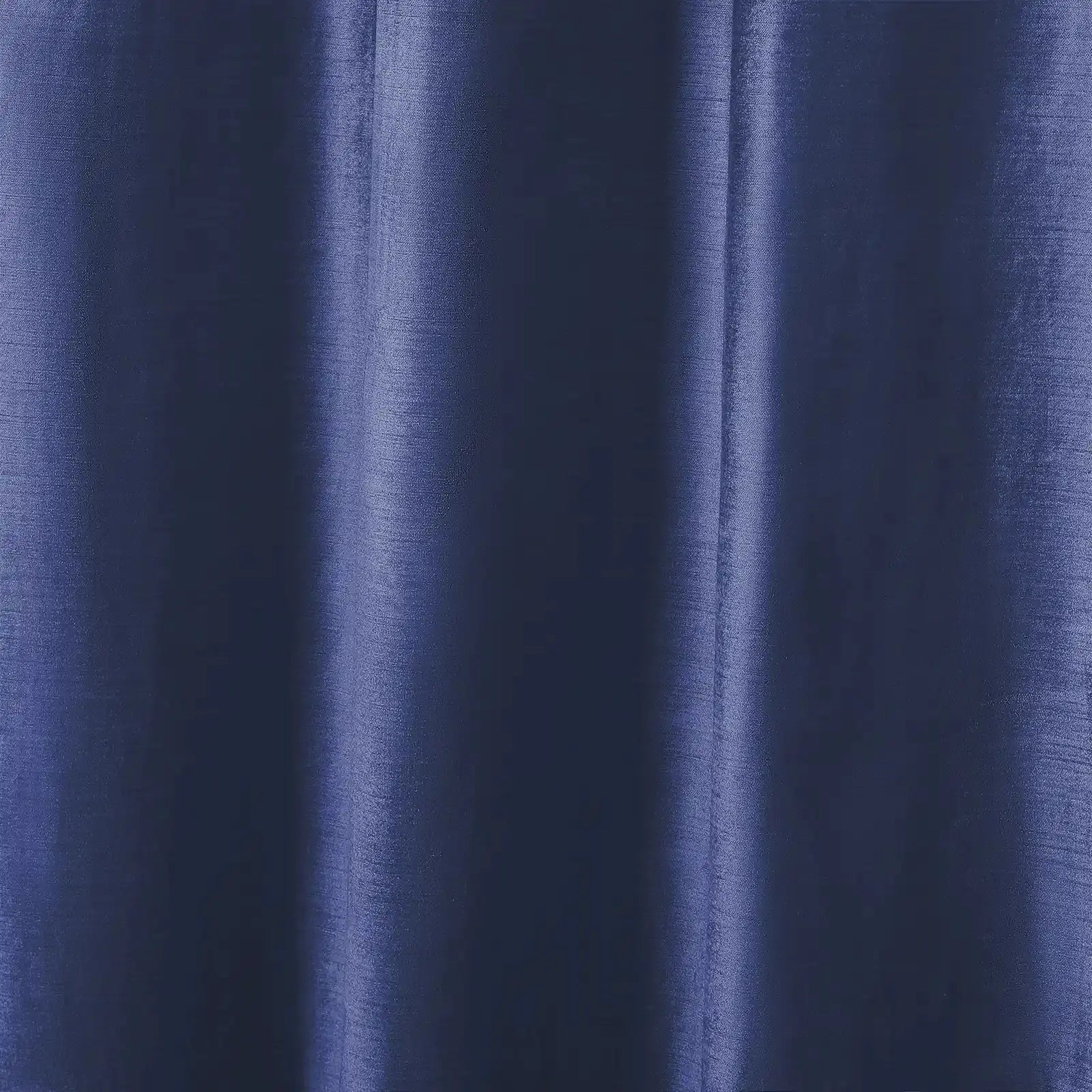 Photograph of deep indigo blue fabric showcasing subtle vertical folds, a textured weave, and shimmering highlights along the drapes