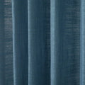 Photograph of deep teal blue woven fabric curtains showing prominent vertical folds and subtle light variations across its textured surface