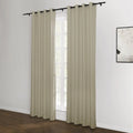 Beige grommet top curtains hang from a black rod in a bright room with a window revealing trees outside, an abstract black and white artwork hangs on the right white wall above a dark wood floor