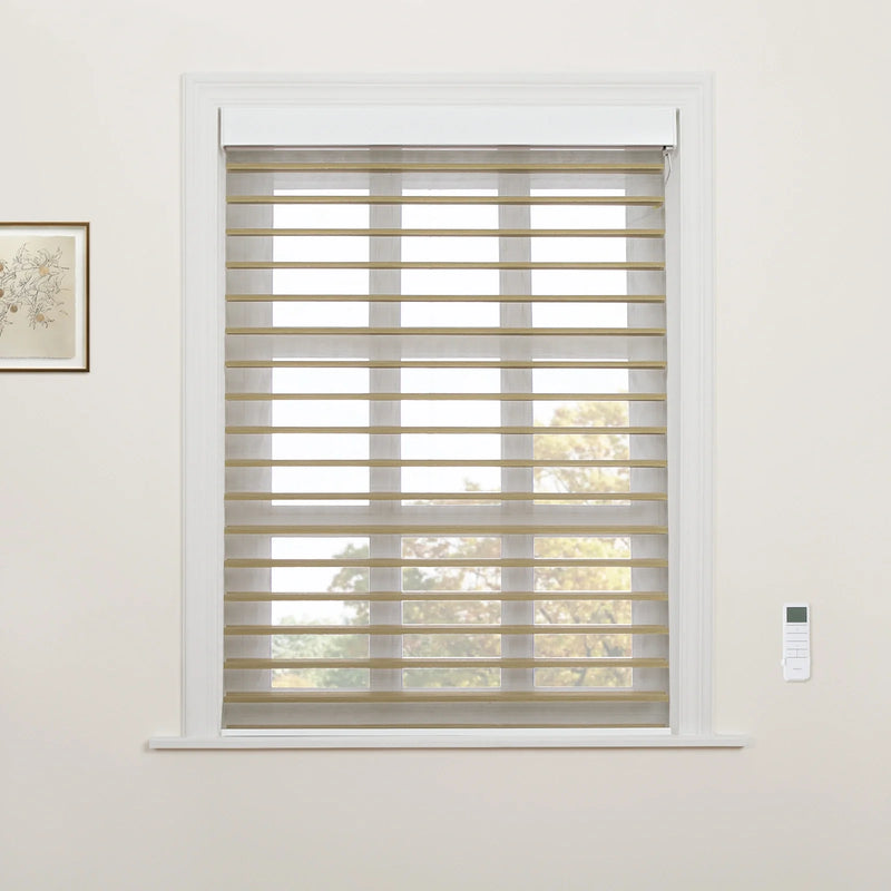 White-trimmed window featuring tan and sheer striped zebra Blinds, a white remote control on the right wall, a framed botanical print on the left, and autumn trees visible through the window
