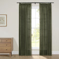 Pleated dark green patterned curtains on a black rod adorn a bright window in a contemporary room featuring a light wood mid-century modern dresser with brass pulls and a framed botanical print artwork