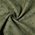 Textured olive green fabric featuring a subtle dark gray floral vine pattern and a prominent central swirl of drapery