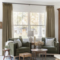Oak Dim Gray Liz Linen Pleated Curtains framing a green sofa beneath a wide sunlit window