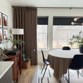 Oak Dim Gray Liz Linen Pleated Curtains around windows beside a round dining table and black chairs