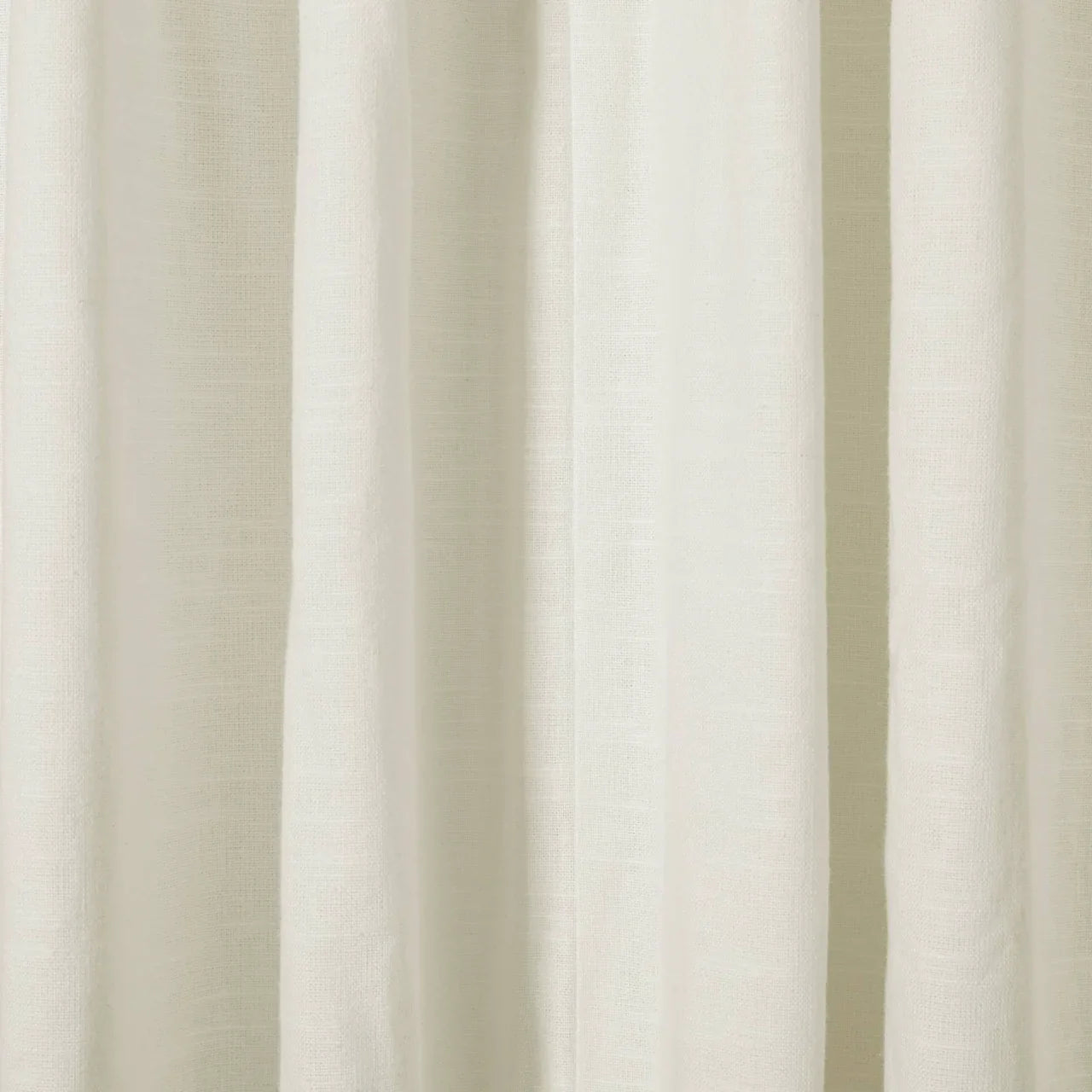 Close-up of draped off-white textured fabric showing subtle vertical folds and a natural woven weave