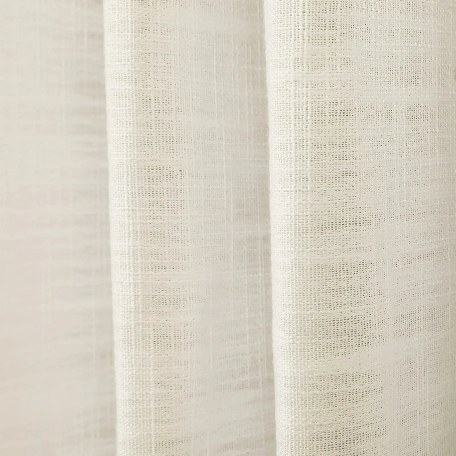 Digital Photograph of a cream-colored linen-like fabric curtain featuring a coarse open weave and gentle vertical folds