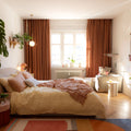 Orange Copper Liz linen curtains viewed at an angle in a softly styled room with natural daylight