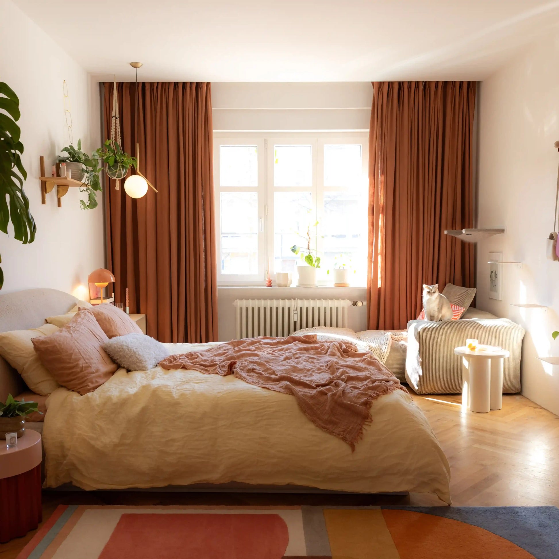 Orange Copper Liz linen curtains viewed at an angle in a softly styled room with natural daylight