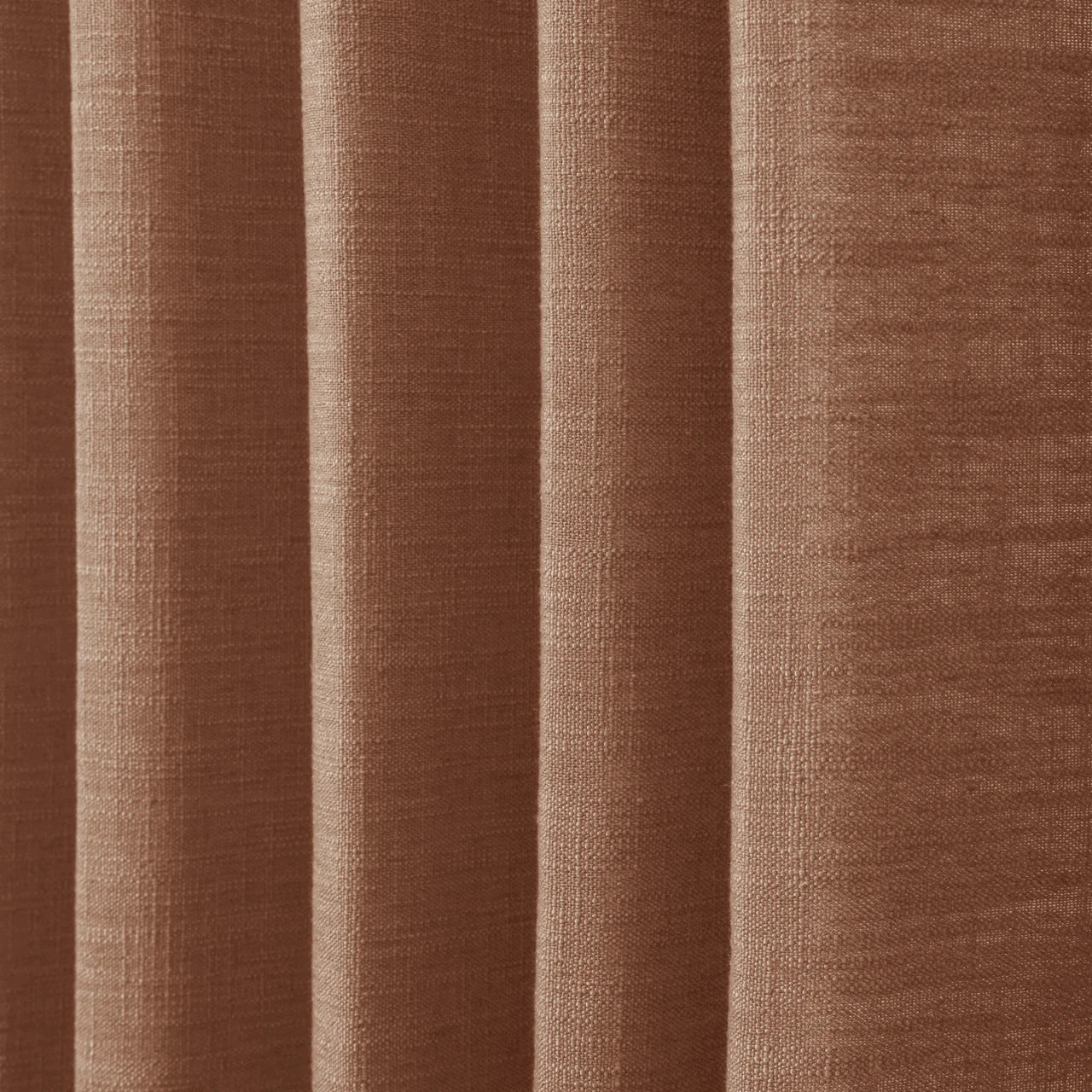 Orange Copper Liz linen curtains in a wider lifestyle scene with furnishings and softly flowing folds