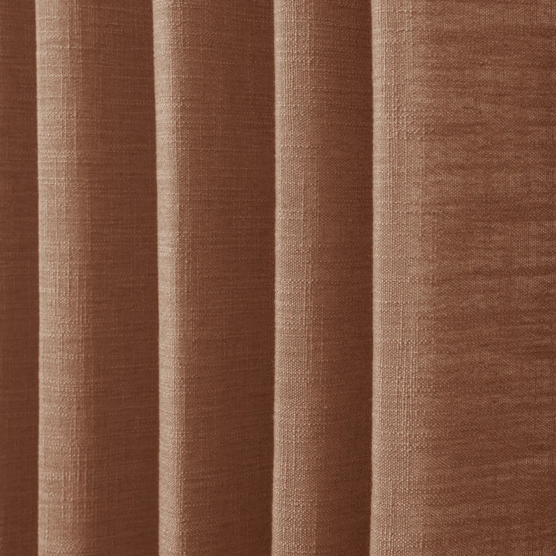Orange Copper Liz linen curtains in a wider lifestyle scene with furnishings and softly flowing folds