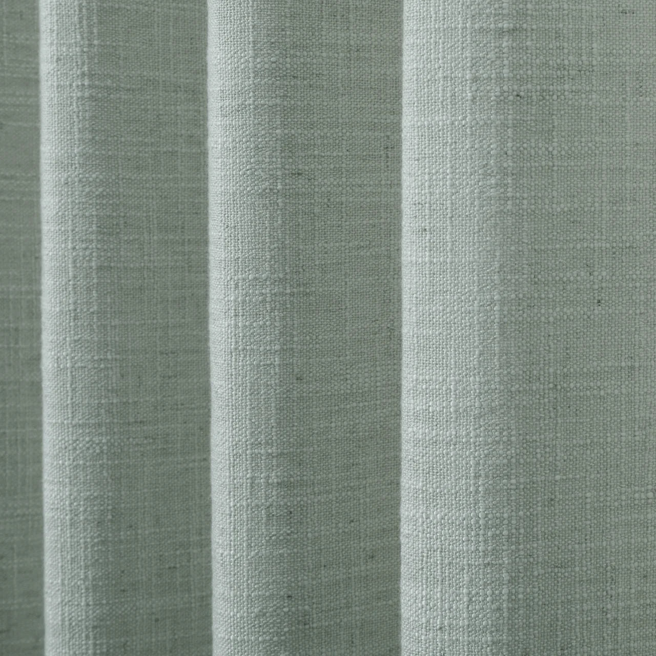 Pale Blue Aqua Liz linen curtains drawn partly across the window with filtered light revealing the weave