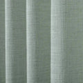 Textile featuring light sage green woven fabric with a distinct slubby texture arranged in soft vertical pleats