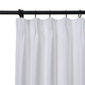 White textured fabric curtain with pleated top hanging from a black metal rod with black rings against a white background