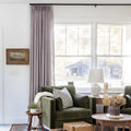 Parchment Liz linen curtains shown closer beside a sunlit window with smooth vertical folds