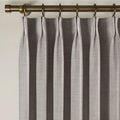 Parchment Liz linen curtains viewed at an angle in a softly styled room with natural daylight