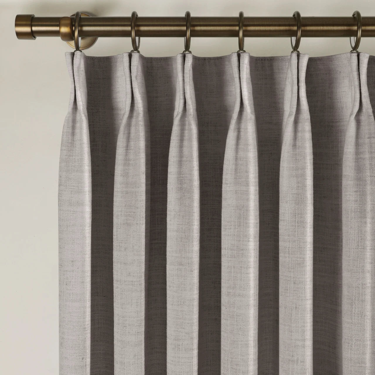 Parchment Liz linen curtains viewed at an angle in a softly styled room with natural daylight