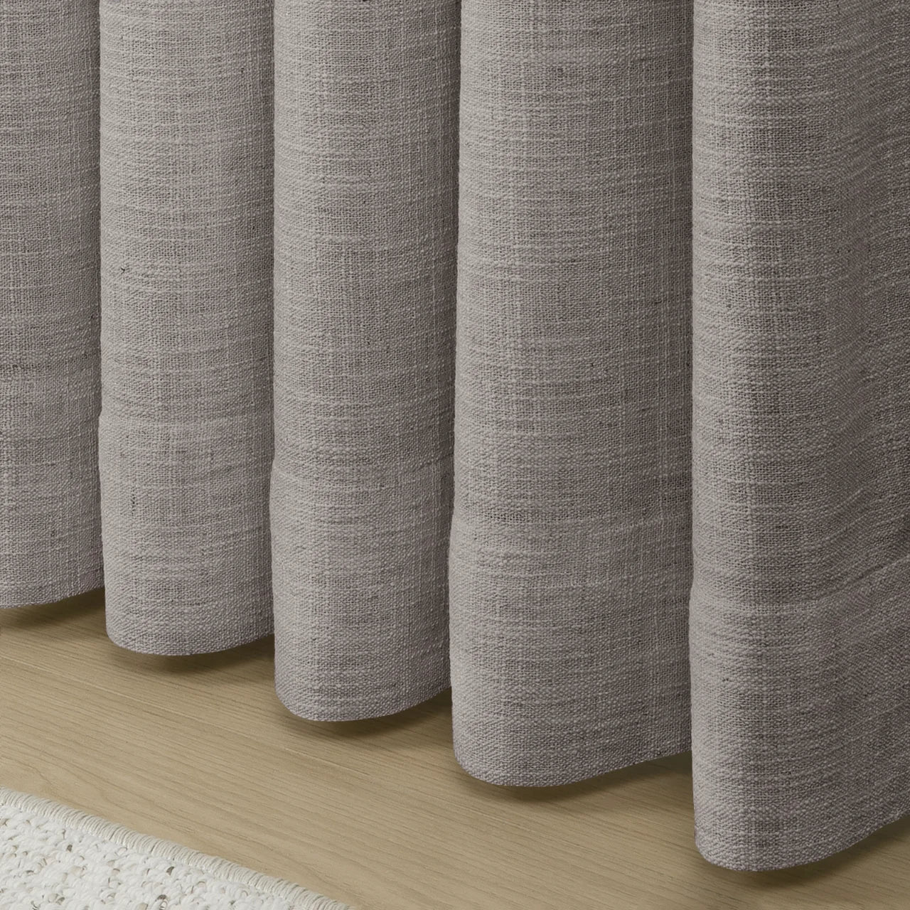 Parchment Liz linen curtains showing the lower drape and pooling folds near the floor