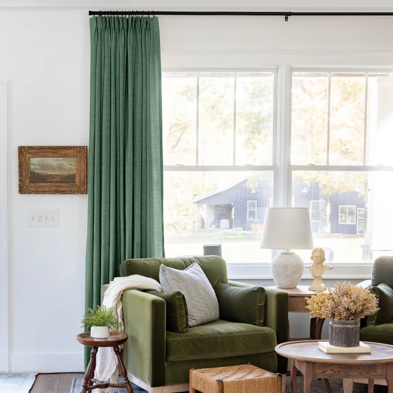 Peacock Liz linen curtains shown closer beside a sunlit window with smooth vertical folds