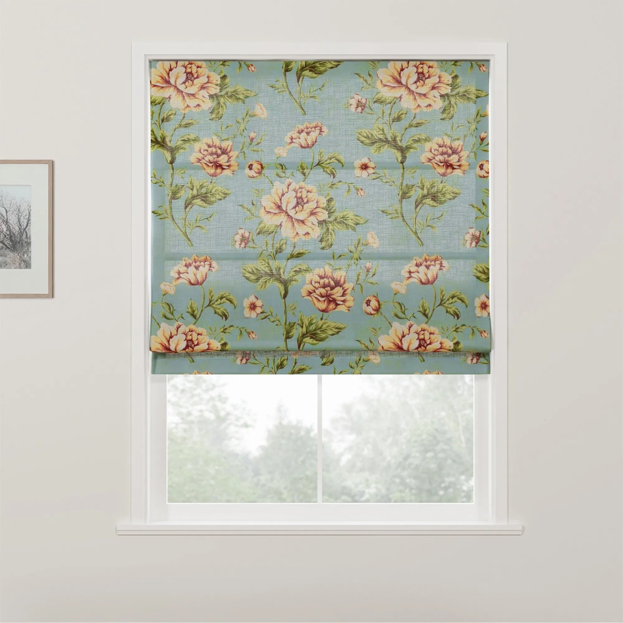 Fabric roman blind featuring a vintage floral pattern with large peach and yellow roses and green leaves on a teal blue background, partially covering a white window with a view of trees