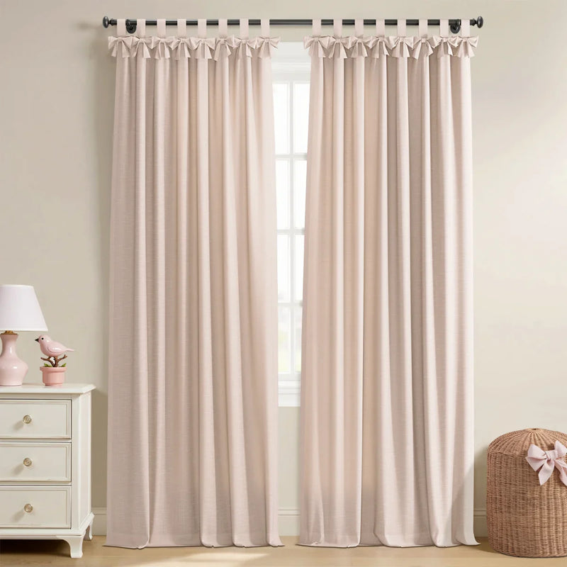 Blush pink linen-look window curtains with bow-knot tab tops in a room featuring a white dresser and a pink lamp