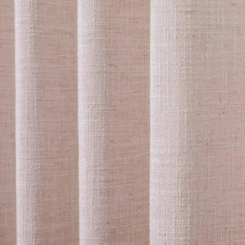 Photograph of an oatmeal-colored linen curtain showcasing a textured slub weave and soft vertical folds