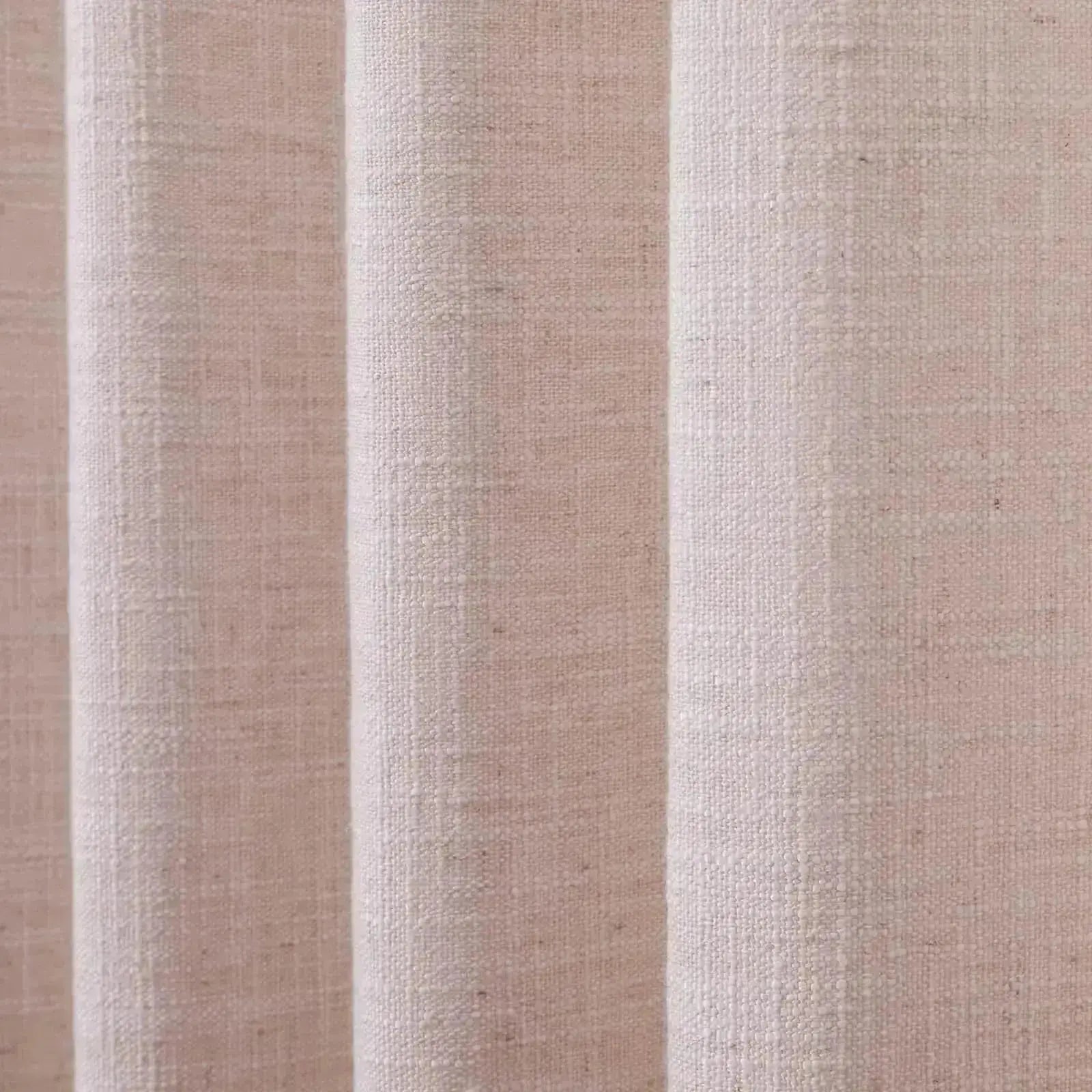 Photograph of an oatmeal-colored linen curtain showcasing a textured slub weave and soft vertical folds